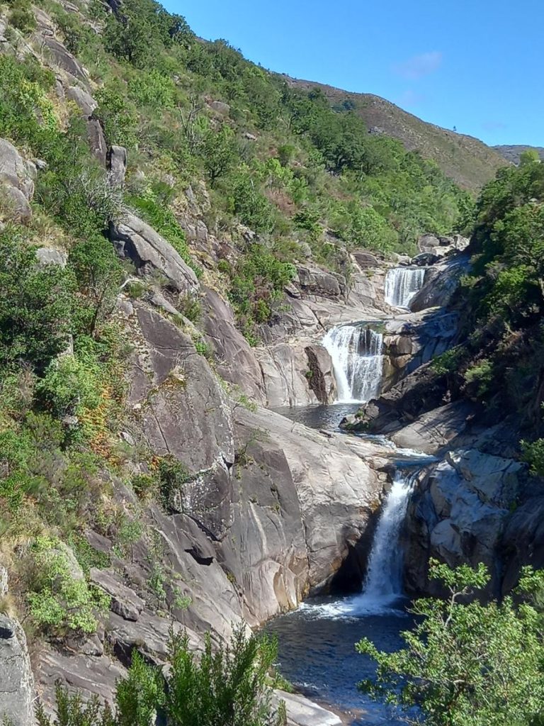 Waterfall among rocks and vegetation